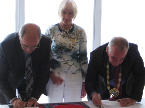 Ives Melet, Vicerecteur of New Caledonia, Madam Marie-Claude Mezouar Principal of CollÃ¨ge Jean Mariotti, and Mayor Rick Cooper singing the agreement.